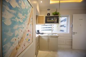 a kitchen with a large painting on the wall at Flat Beira Mar in Fortaleza