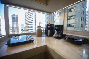 a kitchen with a counter top with a window at Flat Beira Mar in Fortaleza