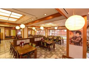 a restaurant with wooden tables and chairs and lights at Yuuai Kumanokan - Vacation STAY 27598v in Matsue