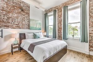 a bedroom with a brick wall and a bed at Delightfully Redesigned Home - JZ Vacation Rentals in Saint Louis