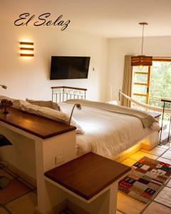 a bedroom with a bed with a desk and a tv at Hospedaje campestre - El Solaz Suites in Villa de Leyva