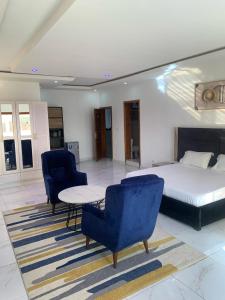 a bedroom with a bed and two chairs and a table at BI HOTEL 2 in Dakar