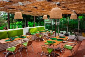 a restaurant with tables and chairs and green at Hospedaje campestre - El Solaz Suites in Villa de Leyva