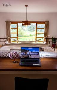 a laptop computer sitting on a desk in front of a bed at Hospedaje campestre - El Solaz Suites in Villa de Leyva