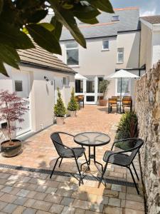 a patio with a table and chairs in front of a house at Allium in Tenby