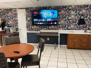 a kitchen with a table and a tv on a wall at SUNSET INN in Branson