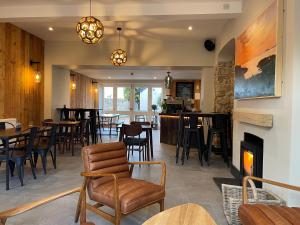 a restaurant with chairs and tables and a fireplace at Allium in Tenby