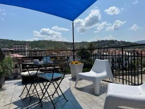 een balkon met een tafel en stoelen en een parasol bij Sapore di mare casa vacanze in Agropoli