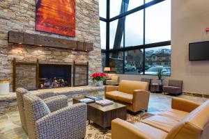 a living room with couches and a stone fireplace at Prospector Studio Getaway in Park City