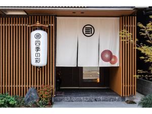 une porte d'entrée d'un bâtiment avec un panneau sur celui-ci dans l'établissement SHIKI Seasonal Colors Kanazawa - Vacation STAY 46392v, à Kanazawa