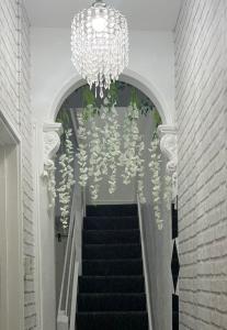 a staircase with a chandelier and a chandelier at Lovely Guest House in Kent