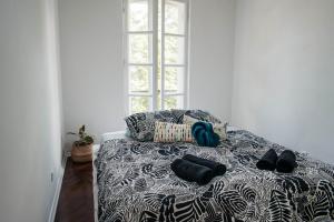 a bed with black and white sheets and shoes on it at Villa Mavro Mavrovo in Mavrovo