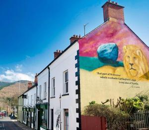 a building with a lion painted on the side of it at Mountain View Shepherds Hut in Kilkeel