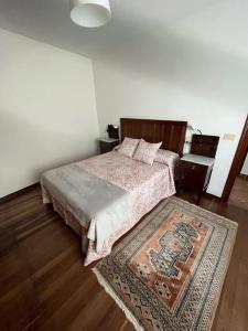 a bedroom with a bed and a rug on the floor at Apartamento DENTRO DE MURALLA y PARKING GRATUITO en pleno centro in Lugo