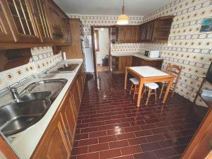 Una cocina con un fregadero y una mesa dentro. en Apartamento DENTRO DE MURALLA y PARKING GRATUITO en pleno centro, en Lugo