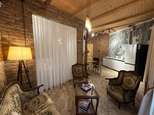ein Wohnzimmer mit einem Sofa, Stühlen und einem Tisch in der Unterkunft Сity center Loft style Apartment in Tbilisi City