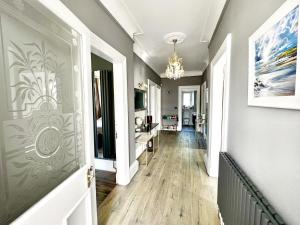 a hallway with a painting on the wall and a chandelier at Immanuel House - Modern Victorian Home 1872 - Free Parking & Fast Fibre Optic WiFi in Edinburgh