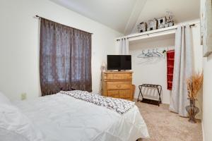 a bedroom with a bed and a television and a dresser at Salem Getaway with Hot Tub Near Parks and Boating! in Salem