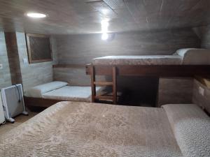Zimmer mit 3 Betten, einem Tisch und einem Stuhl in der Unterkunft Casa Mirian in Arroyo Frio