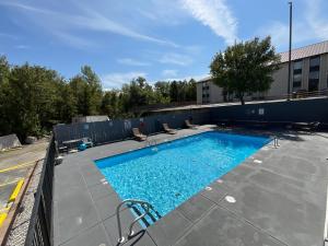 une piscine avec des chaises et un bâtiment dans l'établissement SUNSET INN, à Branson