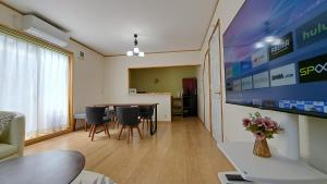 ein Wohnzimmer mit einem Tisch und Stühlen sowie einem TV in der Unterkunft Guest House Jino - Vacation STAY 15446 in Takayama