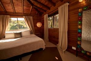 una camera da letto con un letto in una stanza con finestre di Mansión by Bernalo Hotels a Guatapé Altre 37 foto
