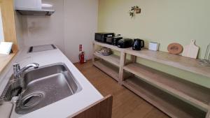uma cozinha com um lavatório e um balcão em Guest House Jino - Vacation STAY 15446 em Takayama