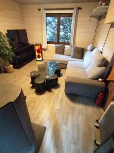 un soggiorno con un divano e un tavolo di Châlet 8 personnes + grand terrain et rivière a Entremont