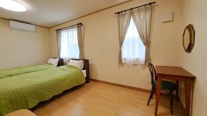 1 Schlafzimmer mit 2 Betten, einem Schreibtisch und einem Tisch in der Unterkunft Guest House Jino - Vacation STAY 15446 in Takayama