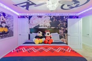 2 animaux farcis assis sur un lit dans une chambre dans l'établissement Amazing Thematic House Pvt PoolArcades Resort, à Orlando