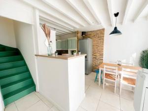uma cozinha e sala de jantar com paredes verdes e brancas em Tiam Anh-TiAM CONCIERGERIE DISNEY Maison PARKING Gratuit em Bailly-Romainvilliers