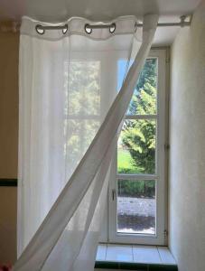 una ventana con una cortina blanca en una habitación en Chez Vanessa, en Saint-Gervais-dʼAuvergne