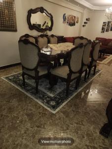 mesa de comedor con sillas y espejo en شقه مفروشه, en Alejandría