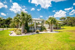 a park with palm trees and a gazebo at Beach Therapy in Caswell Beach