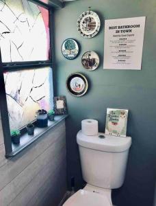 a bathroom with a toilet and some plates on the wall at The perfect Little Cottage for your gateway! in Umatilla