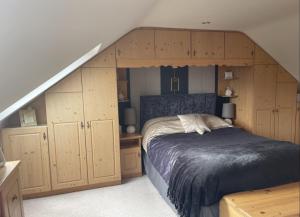 a bedroom with a bed and wooden cabinets and a staircase at Breezy Point Guesthouse in Donegal