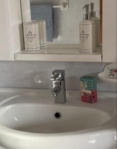 a white bathroom sink with two soap dispensers on a shelf at Breezy Point Guesthouse in Donegal