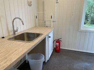 a kitchen with a sink and a red fire extinguisher at Stor hytte med fantastisk utsikt 