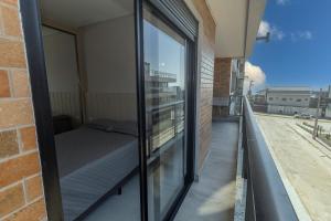 a balcony of a building with a bed on it at 139C - lindo apartamento a 50m da praia de Canto Grande in Bombas