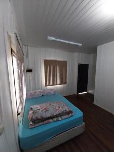 a bedroom with a blue bed in a room at Casa em Blumenau Oktoberfest e demais eventos até 13 pessoas in Blumenau