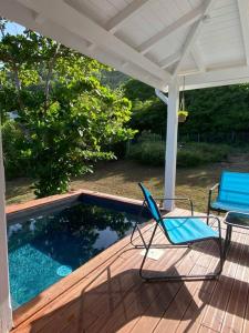 a patio with two chairs and a swimming pool at Bungalow l'amandier avec piscine in Terre-de-Haut