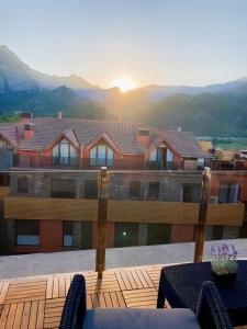 balcón con vistas a una casa con montañas en Apartament dúplex amb vistes al Pirineu català, en Coll de Nargó
