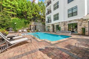 a swimming pool in front of a building at Luxe 2 Bedroom Oasis near Cobb and Truist Park in Atlanta
