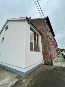 un edificio blanco junto a un edificio de ladrillo en Capstay La Louvière, en La Louvière