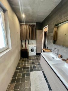 a bathroom with a sink and a washing machine at Capstay La Louvière in La Louvière