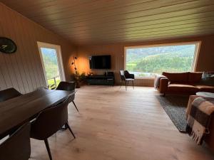 a living room with a couch and a table at Stor hytte med fantastisk utsikt 