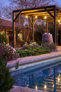 una pérgola y una piscina por la noche en Hotel Hoja de Parra en Santa Cruz