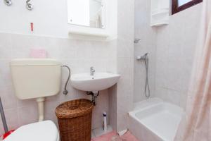 La salle de bains est pourvue de toilettes, d'un lavabo et d'une douche. dans l'établissement Apartments Nemo, à Vinišće