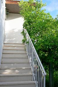 un escalier menant à une maison avec une brousse dans l'établissement Apartments Nemo, à Vinišće