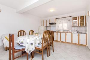 eine Küche und ein Esszimmer mit Tisch und Stühlen in der Unterkunft House Jozo in Marina